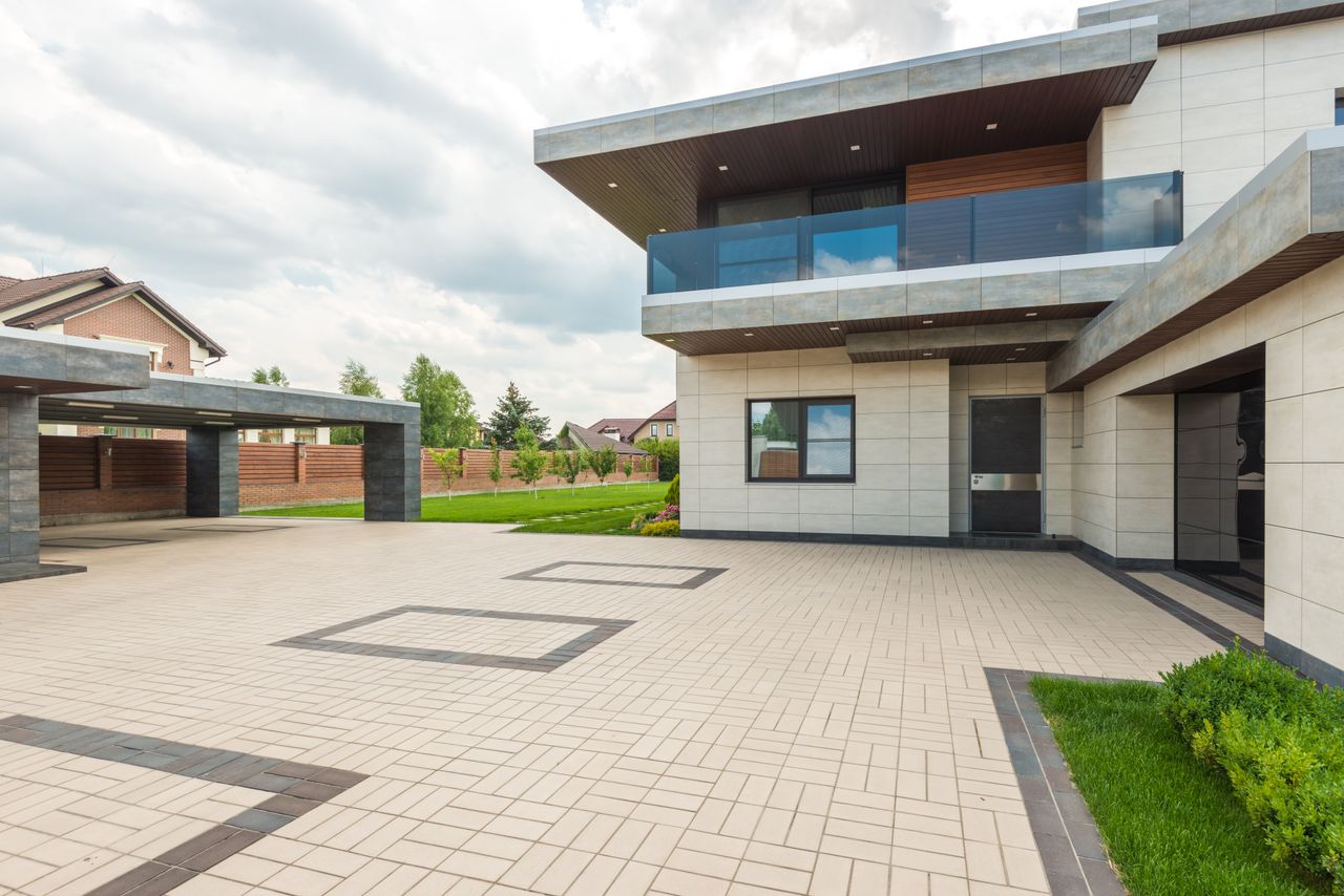 Contemporary residence with sleek design, large driveway, and landscaped yard.